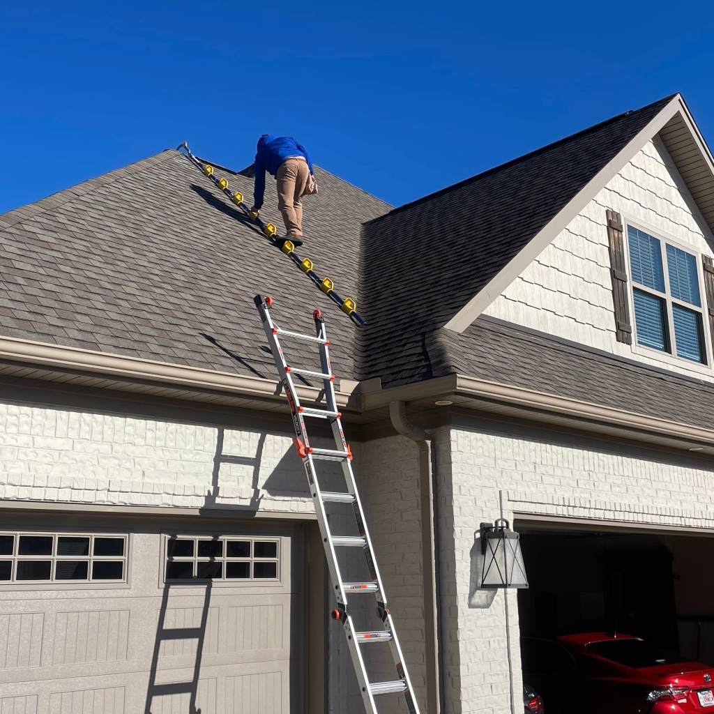 Home inspector examining roof for shingle condition, flashing, and proper installation